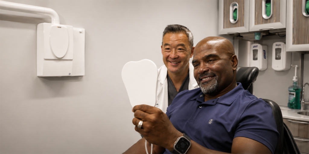 Dr. Chin smiling with his patient who is also smiling into a mirror