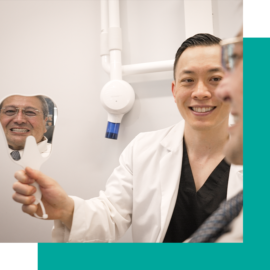 Dr. Wong with his patient smiling into a tooth mirror