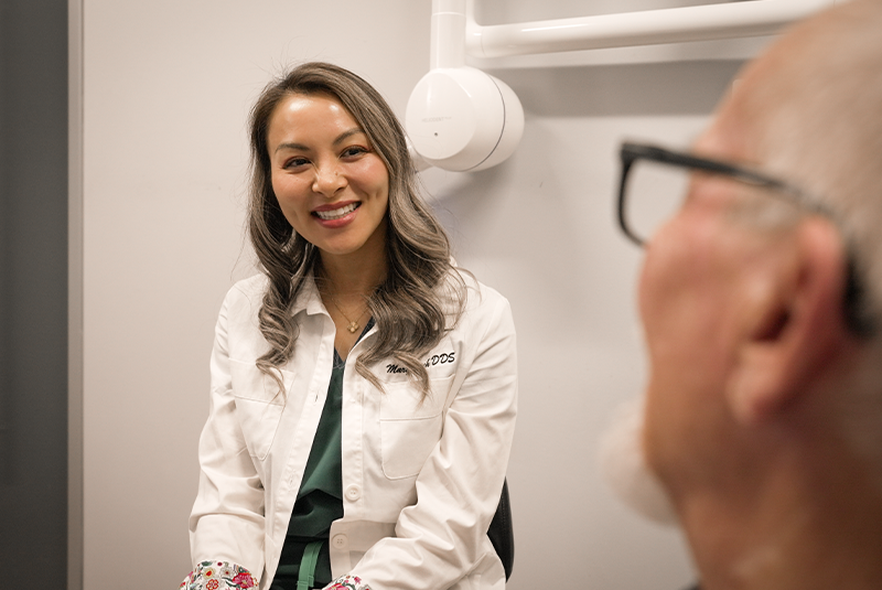 Dr. Dinh smiling with her patient in the consult room