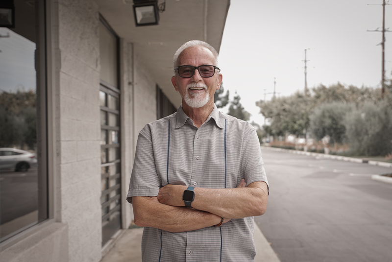 male patient standing outside the office with his arms folded
