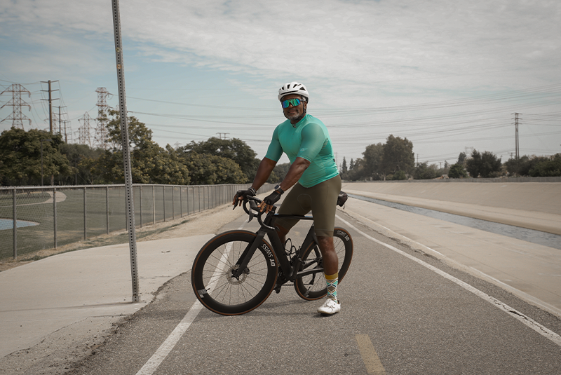 male patient outside smiling on his bicycle.