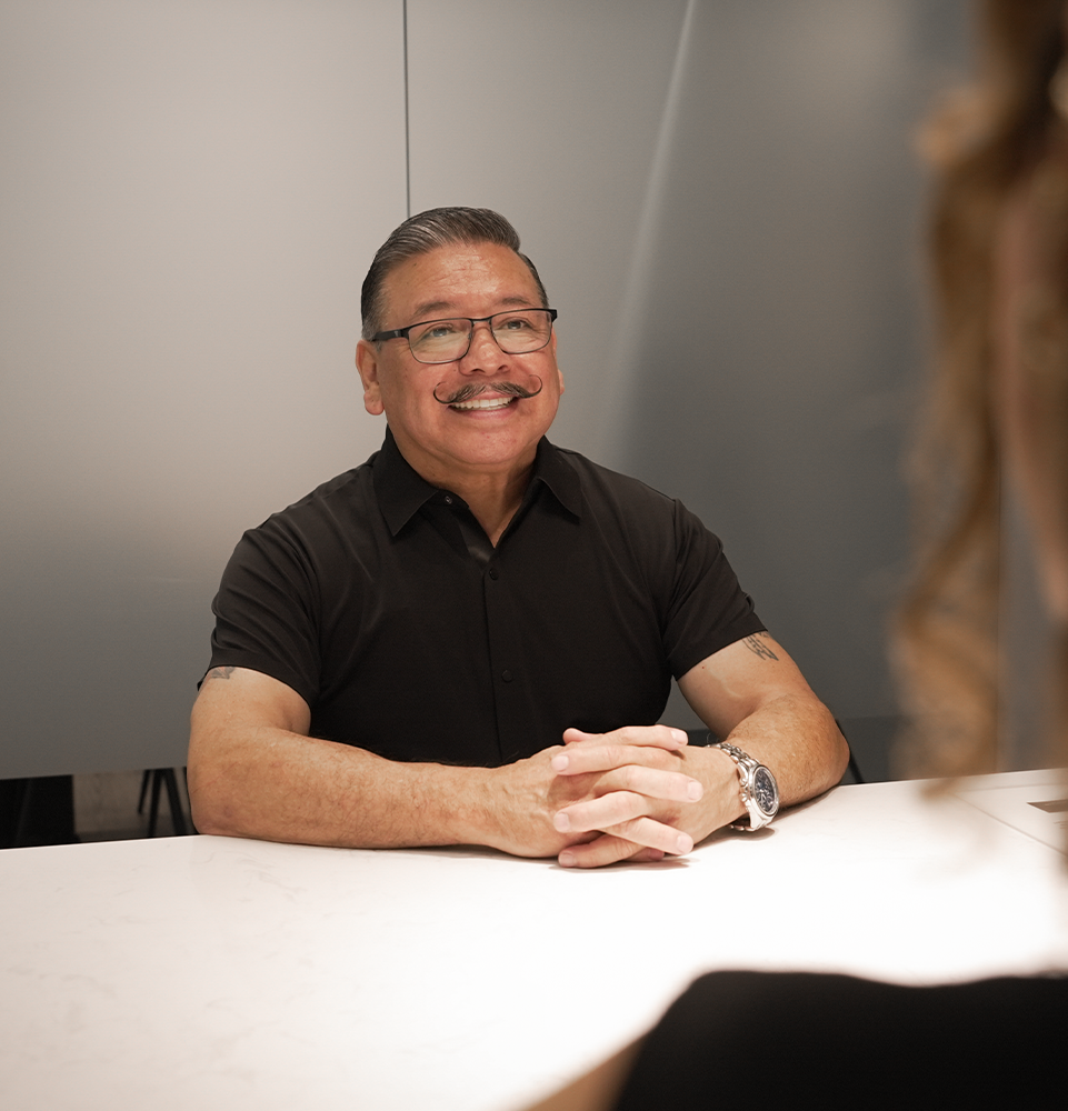 male patient sitting in the treatment planning room smiling at a staff member